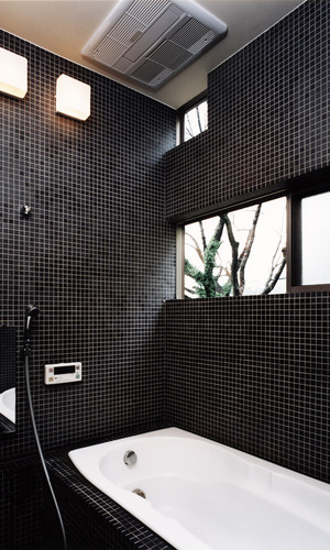 黒のタイルで統一した、窓からの四季を楽しめる在来浴室
