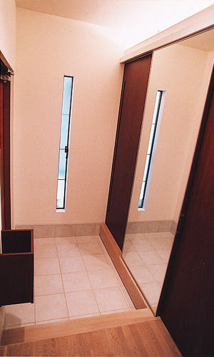 収納用引き戸一枚を可動式鏡に仕立てた、実用性とデザイン性が行き届いた玄関