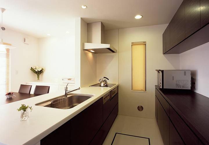 白と焦げ茶でトラッドなテイストでまとめた、無駄のないシンプルなキッチン