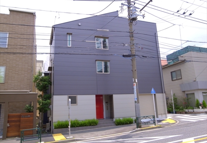 赤いドアが差し色の外観