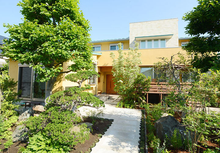 自然に囲まれる優しい色合いの家