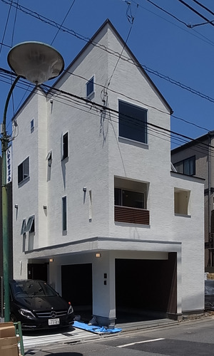 東側前面道路、南よりから建物の全景をみる