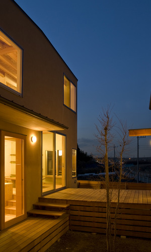 三つに分棟した建物で囲まれた中庭の夜景