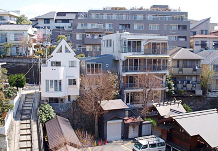 都心に住むために見つけた崖上の土地に建つ小さな家