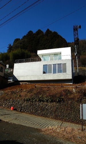 急勾配の傾斜地に浮かぶ、箱のような住宅