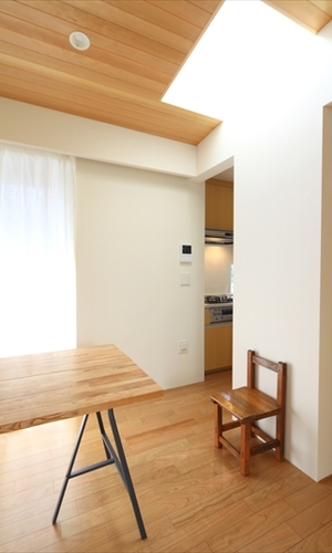 白い壁にトップライトの光が反射する明るい空間