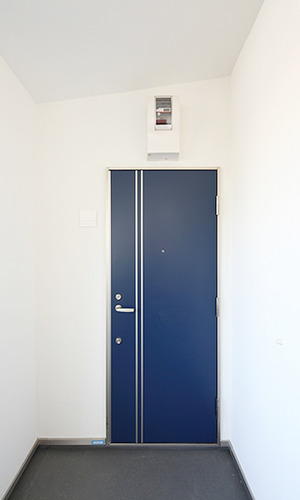 白い壁に映えるネイビーの玄関ドア