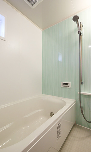 パステルグリーンの壁が爽やかなバスルーム