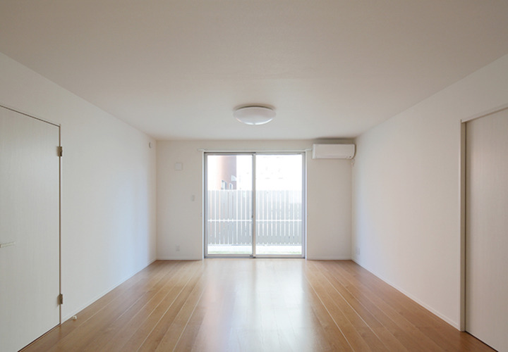 白い壁とナチュラルなフローリングのリビング