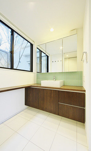 白い壁と木目調でまとめたナチュラルな洗面ルーム