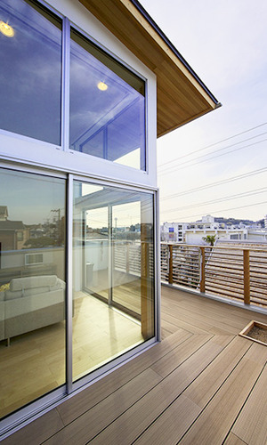 眺望を楽しむ開放的なリビングとウッドデッキ