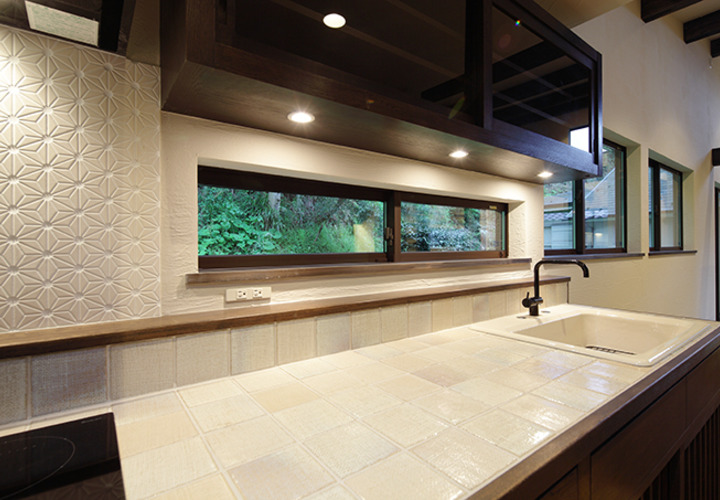 横長の引き違い窓に面したキッチン