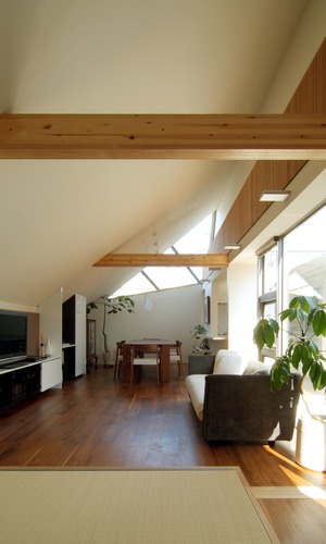 傾斜した天井と木の梁が印象的な　リビングダイニング