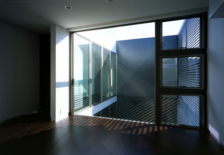 コートヤードの上部から明るい日差しが差し込む寝室