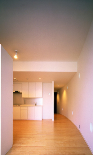 湾曲した壁にある丸い光が差し込むワンルーム