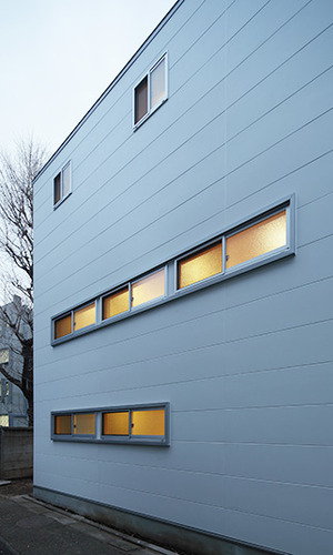 長窓からの灯りが白い外観に彩りを添える