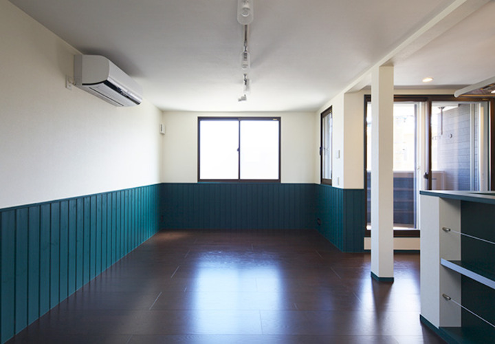 グリーンの腰壁が映える開放的なリビング