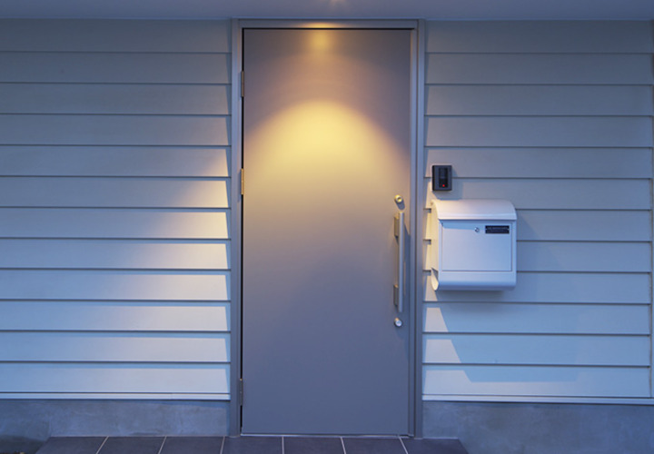 白いポストとスタイリッシュなステンレス扉がモダンな雰囲気を演出する玄関