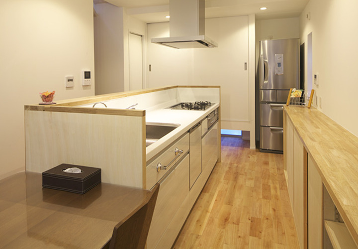 シンプルながら機能的なアイランドキッチンと造り付け収納