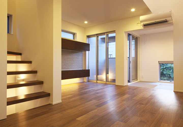 バルコニーへと開いた落ち着きあるフローリングのリビング