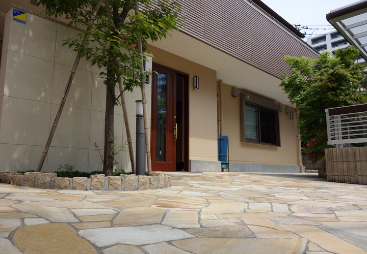 無造作のタイルと緑のある玄関ポーチ