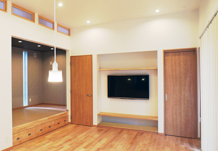 キッチンからこあがりのあるリビングを眺める