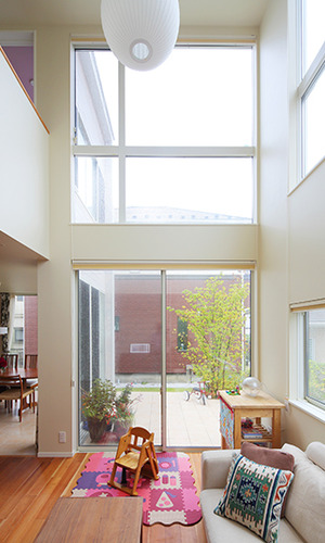 窓に囲まれ吹き抜けのある開放的なリビング