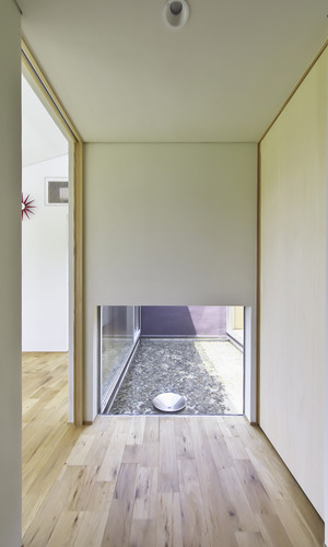 玄関を入ると、正面の地窓から覗く水盤が出迎える。