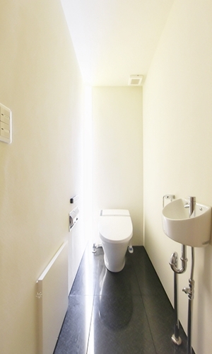 スリット状の窓から光が差し込むトイレ。