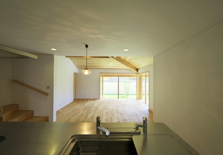 キッチンからダイニング、リビング、そして庭へと視界が繋がる。