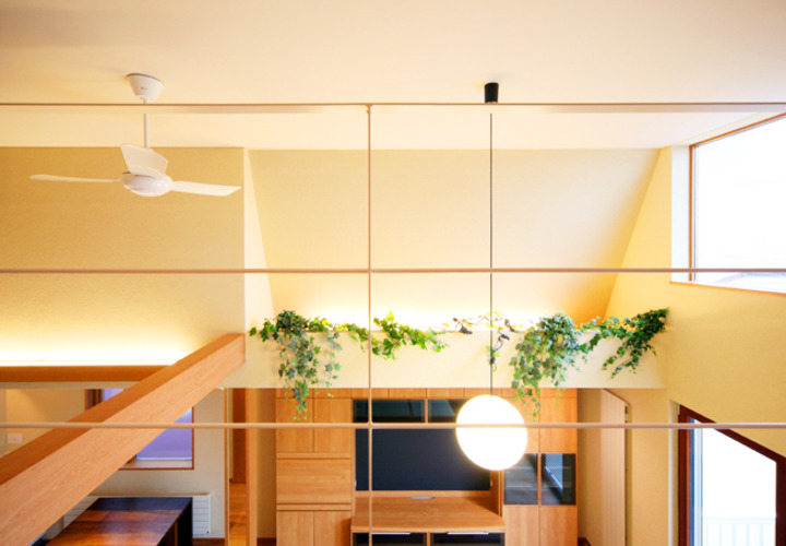 吹き抜けの天井からリビングに光が降り注ぐ