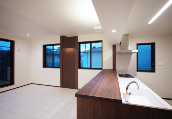 白いキッチンに木目のカウンターがアクセントに