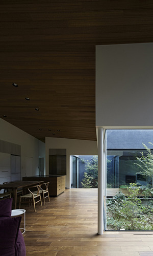 多層に重なる雑木林の中庭がある家