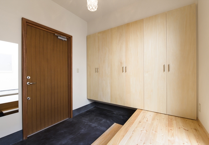 墨色の玄関土間と木製玄関扉