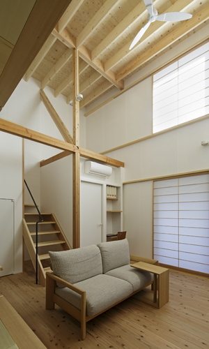 柱・梁・階段などの木の質感が印象的な天井の高い部屋