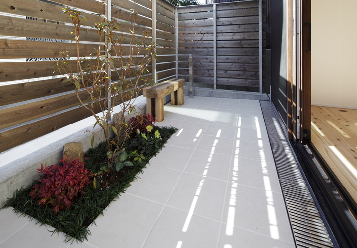 道路からの視線をさえぎって部屋からの眺めを整える板塀で囲まれた小さな庭