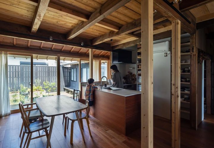 キッチンは間取りに合わせて変則的なL型ペニンシュラで製作。玄関から居間、庭まで見渡せるレイアウト。