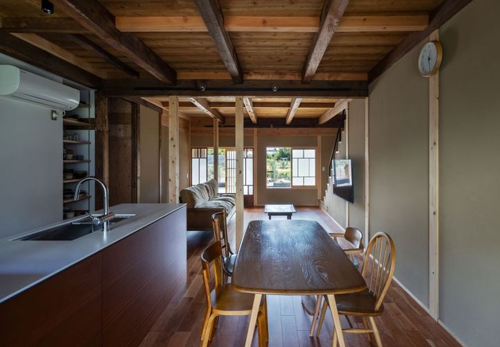 ダイニングから玄関方向。床はチェリー。キッチン面材はサペリ。濃い古材と白い新設材を中間色で取り持つ。