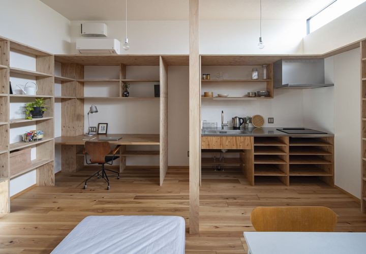デスク・キッチンも合板で製作してビルトン。コーナーの入隅はエアコンのダクトスペースに活用。