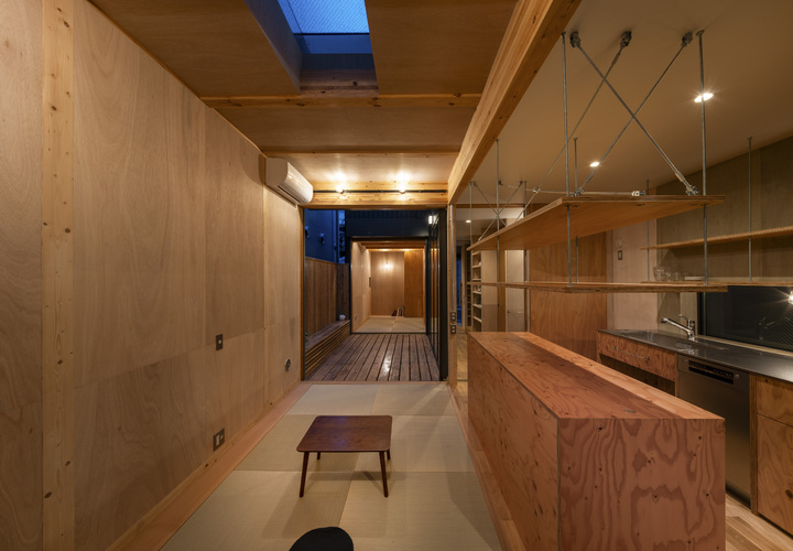 キッチンは幅2,700。シンプルながらアイランドと釣戸棚、食洗機を備え実用性重視。シンク下はオープンにしてゴミ箱を設置。奥に出窓を設けてワークスペースを拡張。