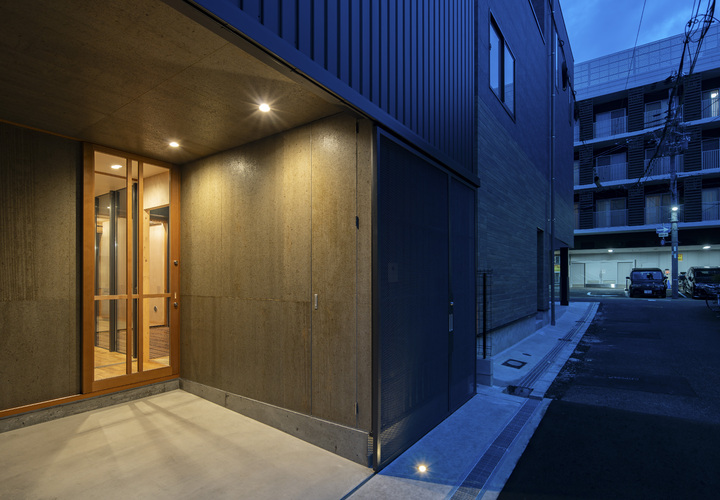 吊戸左手のドアは壁面と同仕上で設えた小さな収納。バイク用品などを整理。