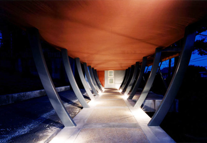 スチールの柱で持ち上げられたスペースを歩いて玄関に