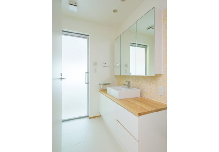 洗面室。浴室のサッシからの日差しが明るい。