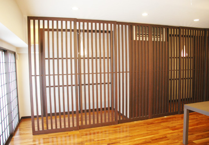 格子戸で仕切られたリビングの一角のベッドコーナー