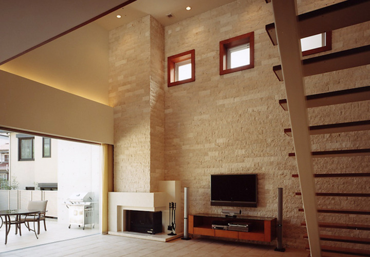 暖炉を楽しむ石張りの吹抜けリビング