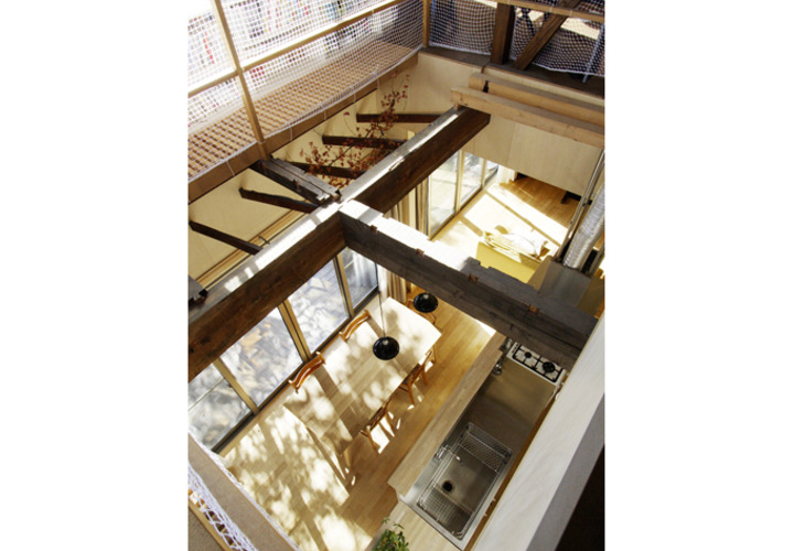 吹抜けから1階キッチンダイニングを見る