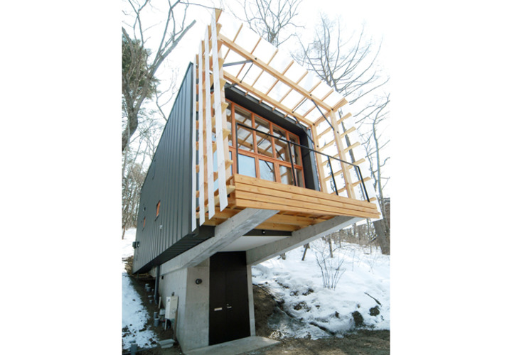 地階の玄関アプローチから上部の建物を見上げる