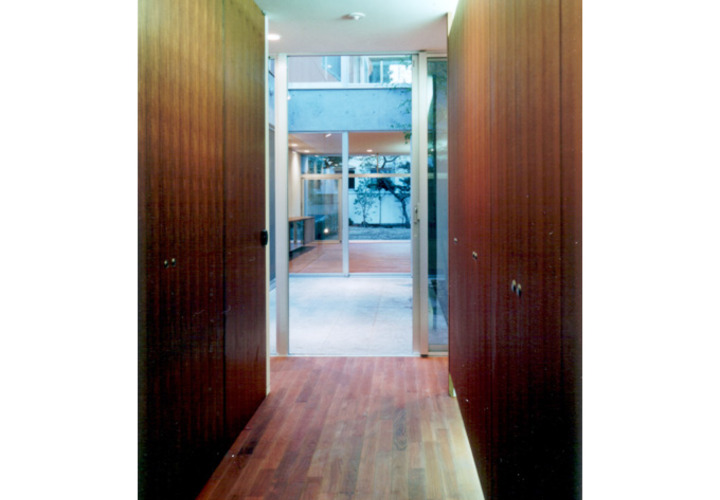 親世帯の玄関から中庭を通してLDKを見る