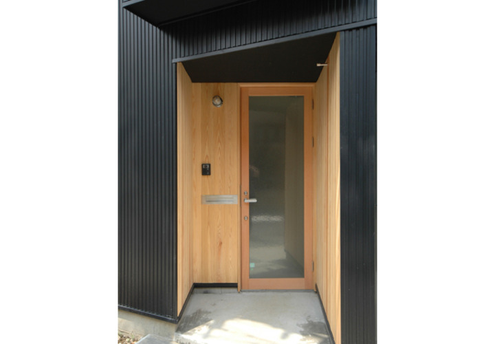 ガラス戸の玄関と木の外壁