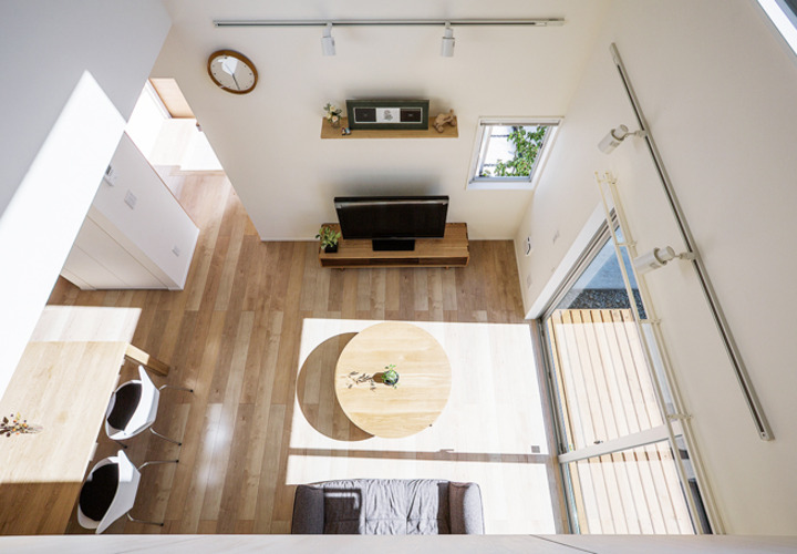 吹抜から見た、日光と影がきれいなリビング